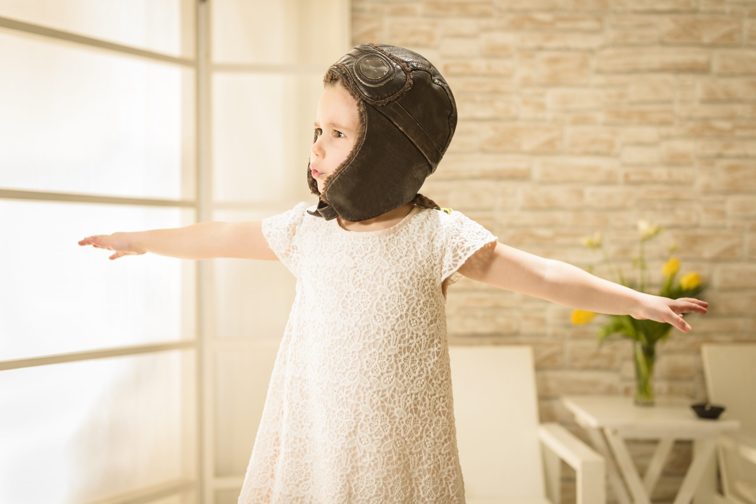 Small girl pretending to be a plane or a bird